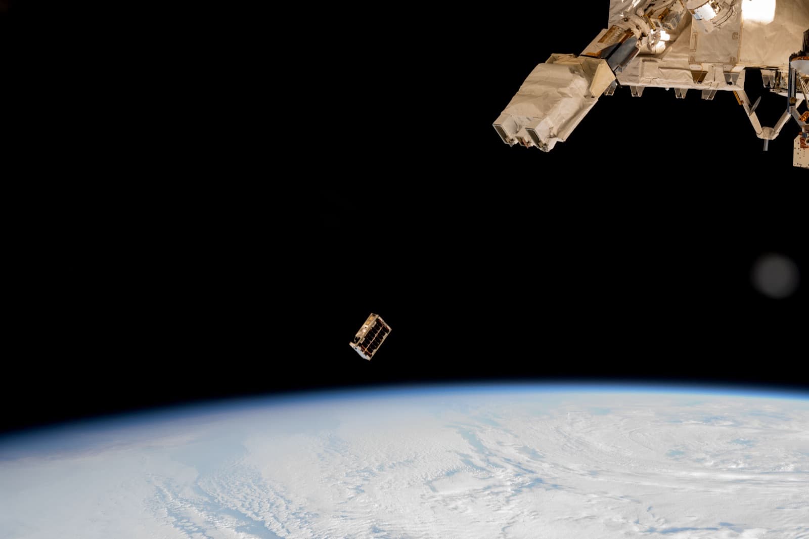A satellite deploying above Earth